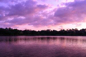 sereno águas uma feliz reflexão do uma lindo pastel lago e céu, Onde tranquilidade encontra da natureza paleta, criando uma harmonioso oásis do suave matizes e etéreo beleza foto