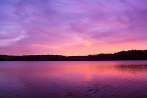 sereno águas uma feliz reflexão do uma lindo pastel lago e céu, Onde tranquilidade encontra da natureza paleta, criando uma harmonioso oásis do suave matizes e etéreo beleza foto