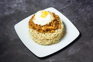 kanton chopsuey com carne, ensolarado ovo e frito Macarrão servido dentro prato isolado em cinzento fundo topo Visão do indiano e Bangladesh Comida foto