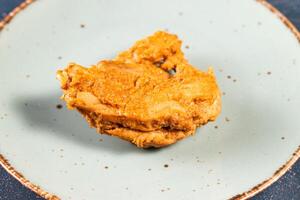 crocantes frito frango peça dentro uma prato isolado em mármore fundo topo Visão velozes Comida foto