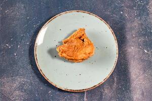 crocantes frito frango peça dentro uma prato isolado em mármore fundo topo Visão velozes Comida foto