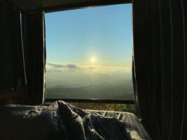 manhã Visão através de madeira janela negligenciar de praia e oceano panorama com aberto céu e luz solar transmissão para dentro quarto foto