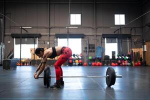 em forma mulher preparando Barra e elevadores para levantamento de peso dentro uma Academia foto