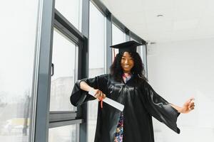 lindo africano fêmea aluna com graduação certificado foto