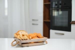 uma kraft caixa com pão produtos, rosquinhas, croissants dentro a cozinha foto