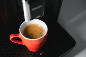 moderno espresso café máquina com uma copo dentro cozinha foto