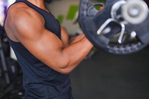 motivado jovem Preto desportista tendo exercite-se em remo máquina foto