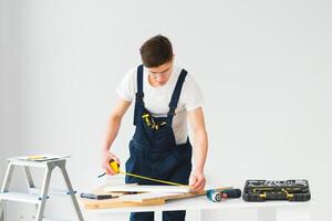 reparar, construção e construção conceito - feliz sorridente masculino trabalhador ou construtor dentro óculos às Novo casa em fundo foto