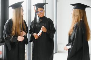 retrato do multirracial graduados segurando diploma foto