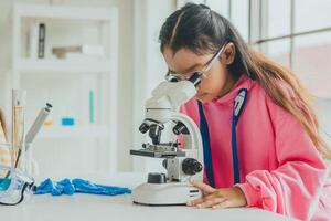 crianças usando microscópios para estude Ciência às escola foto