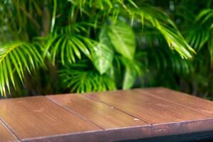 esvaziar mostrar para embalagem produtos apresentação. de madeira mesas e espaços estão conjunto acima com tropical folhagem. foto