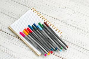 caderno diário para planejamento e estudando em a mesa com colori marcadores. foto
