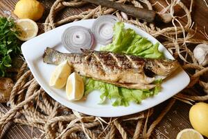 branco prato com fresco peixe e limão guarnição, enfeite, adorno foto