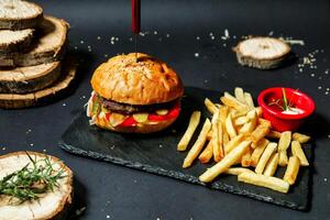 Hamburger e francês fritas em Preto prato foto