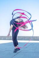 jovem menina fazendo exercício dentro a cidade, mulher fazendo ioga exercício, pessoa fazendo alongamento, mulher relaxante dentro a cidade, bonita menina fazendo ginástica exercício foto