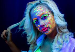 retrato do uma mulher com pintado face, mulher com uv Maquiagem dentro estúdio, retrato do uma mulher dentro carnaval mascarar, a mulher é decorado dentro uma ultravioleta pó foto