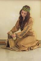 armênio jovem mulher dentro tradicional roupas trabalhando dentro casa foto