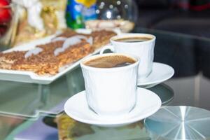 copo do café e bolo em a mesa foto