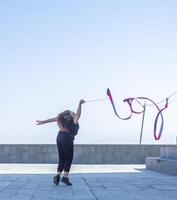 jovem menina fazendo exercício dentro a cidade, mulher fazendo ioga exercício, pessoa fazendo alongamento, mulher relaxante dentro a cidade, bonita menina fazendo ginástica exercício foto