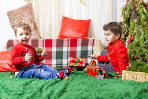 a pequeno criança jogando com Natal decorações dentro estúdio, pequeno criança com Natal bola foto