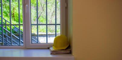 amarelo capacete em janela peitoril foto