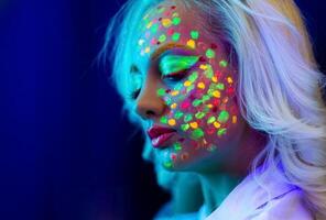 retrato do uma mulher com pintado face, mulher com uv Maquiagem dentro estúdio, retrato do uma mulher dentro carnaval mascarar, a mulher é decorado dentro uma ultravioleta pó foto