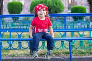 feliz pequeno Garoto jogando dentro a parque, grandes cabelo Garoto dentro a parque foto