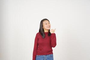 jovem ásia mulher dentro vermelho camiseta apontando lado às cópia de espaço com polegar isolado em branco fundo foto