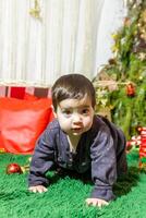 a pequeno criança jogando com Natal decorações dentro estúdio, pequeno criança com Natal bola foto