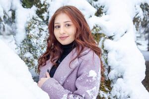 bonita jovem mulher dentro inverno parque, vermelho cabelos menina dentro a parque dentro inverno foto