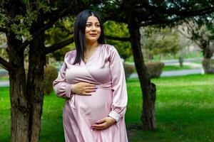 a grávida mulher dentro a parque, lindo mulher dentro a parque, grávida mulher dentro Primavera foto