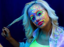 retrato do uma mulher com pintado face, mulher com uv Maquiagem dentro estúdio, retrato do uma mulher dentro carnaval mascarar, a mulher é decorado dentro uma ultravioleta pó foto