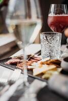 refeições serviço. vinho vidro com vermelho vinho e lanches em a mesa foto