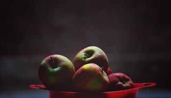 vermelho maçãs dentro uma vermelho tigela em uma Sombrio fundo. seletivo foco. foto