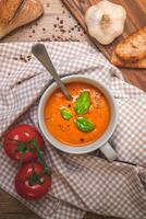 tomate sopa com manjericão, alho e croutons em de madeira fundo foto