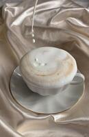 copo do cappuccino com leite em uma seda fundo foto