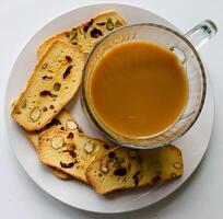 copo do café e biscoito com passas de uva em branco fundo foto