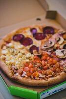 pizza com tomate, mozzarella queijo e cogumelos dentro caixa foto