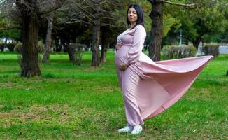 a grávida mulher dentro a parque, lindo mulher dentro a parque, grávida mulher dentro Primavera foto