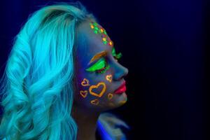 retrato do uma mulher com pintado face, mulher com uv Maquiagem dentro estúdio, retrato do uma mulher dentro carnaval mascarar, a mulher é decorado dentro uma ultravioleta pó foto