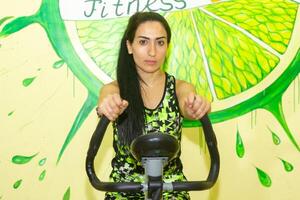 mulher fazendo ginástica exercício, jovem mulher fazendo ginástica exercícios dentro ginástica clube foto