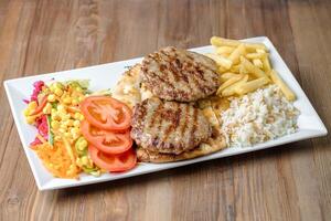 prato com carne, fritas, e legumes em branco fundo foto