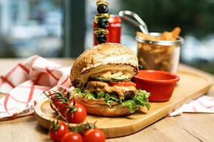 delicioso Hamburger com alface, tomate, e azeitonas em corte borda foto