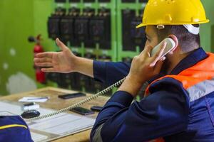 industrial trabalhador com amarelo capacete às a trabalhos foto