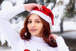 bonita jovem mulher dentro inverno parque, vermelho cabelos menina dentro a parque dentro inverno foto