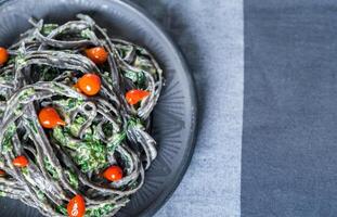 macarrão preto com espinafre, mascarpone e parmesão foto