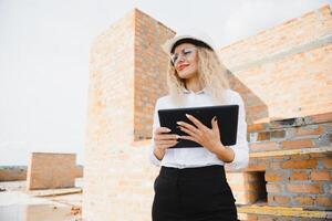 mulheres engenheiro Veja às construção vidro. foto