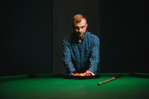 homem jogando bilhar dentro uma clube foto