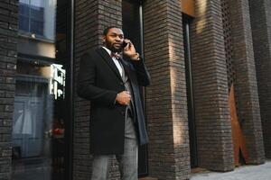 retrato de um homem de negócios americano africano vestindo um terno de pé em um ambiente de negócios ao ar livre foto