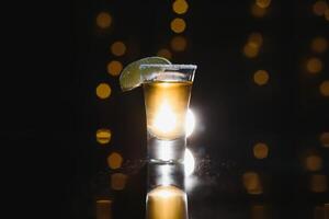 saboroso álcool beber coquetel tequila com Lima e sal em vibrante Sombrio fundo. fechar-se. foto